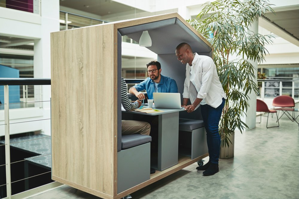 Three work colleagues sitting in an office pod